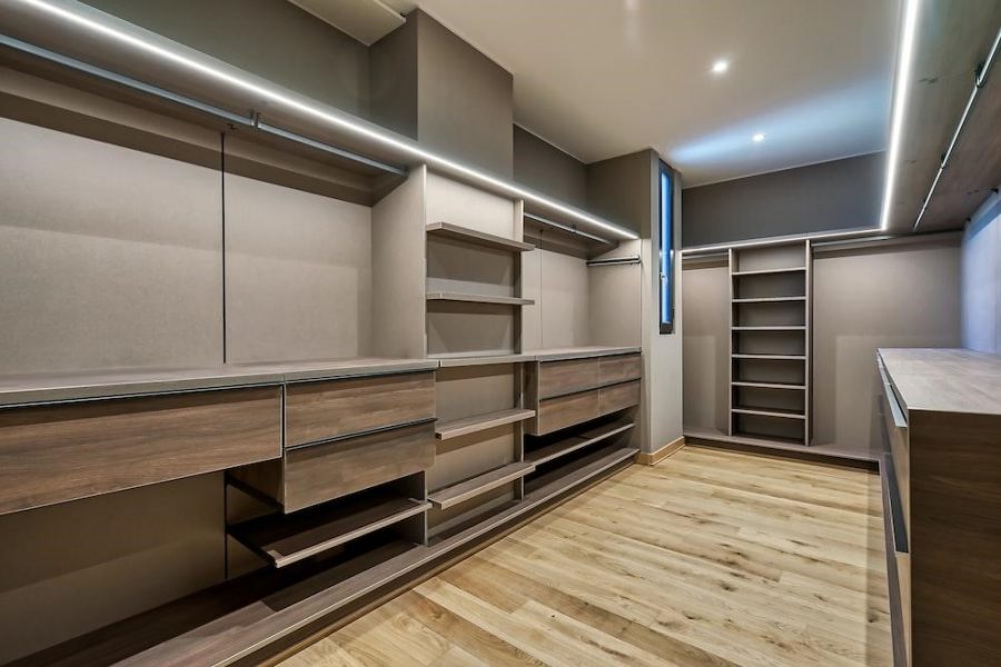 a large walk in closet with a wooden floor