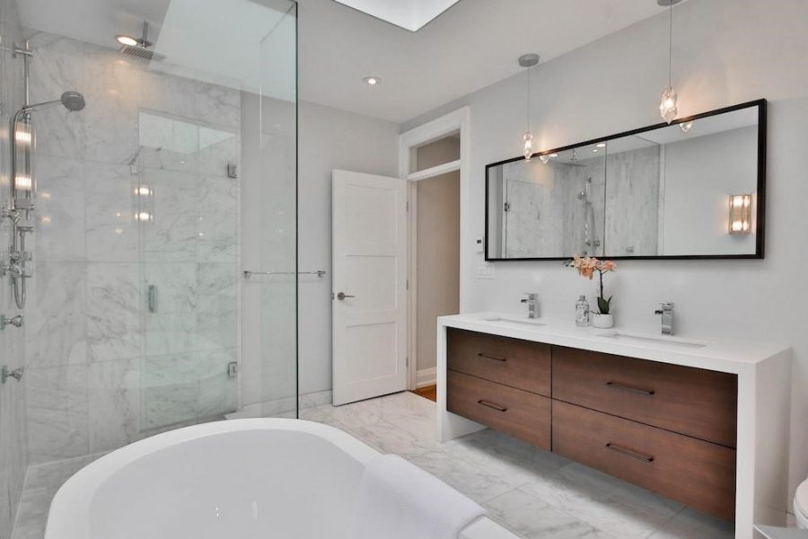 a bathroom with a large white bathtub next to a walk in shower